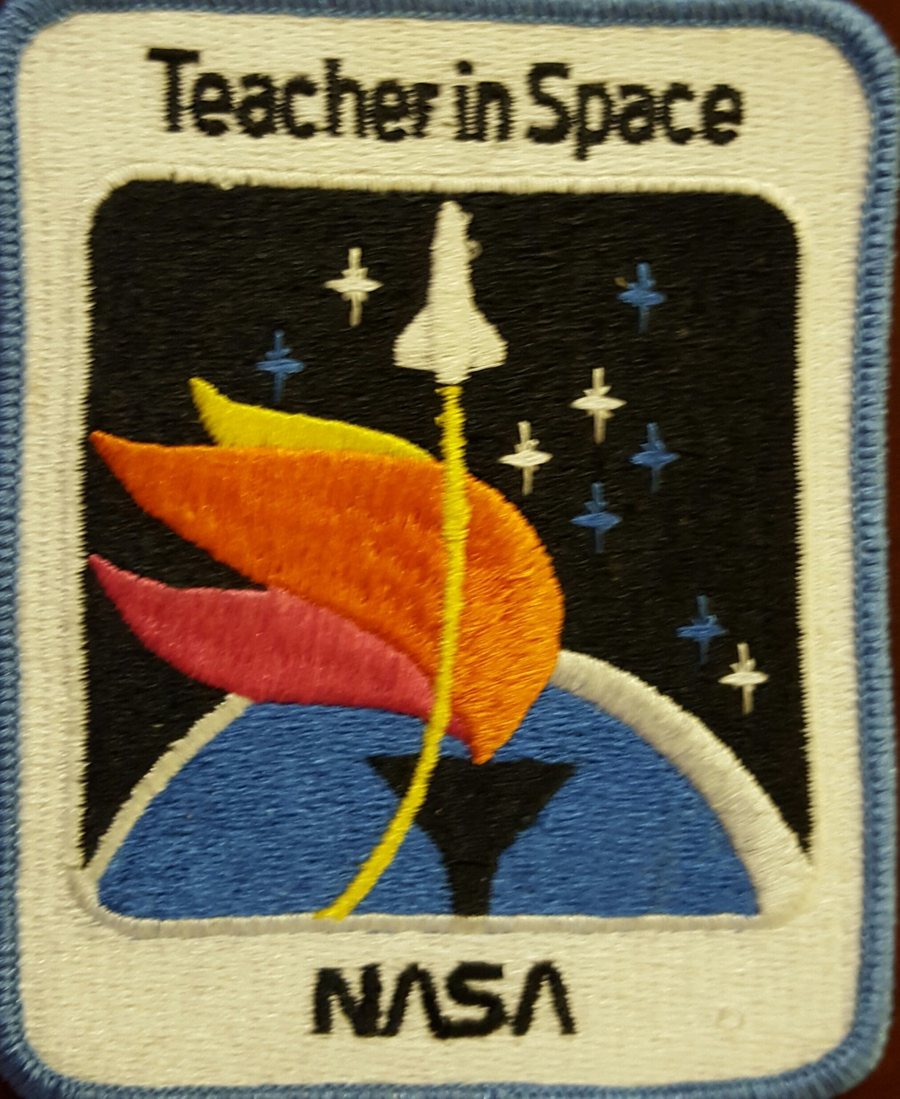The Teacher in Space mission patch, an embroidered NASA patch with the shuttle rising over Earth